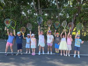 toddlers holding up tennis rackets